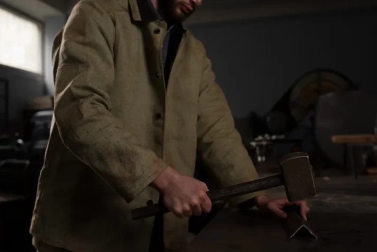 Cropped shot of male worker hammering metal part