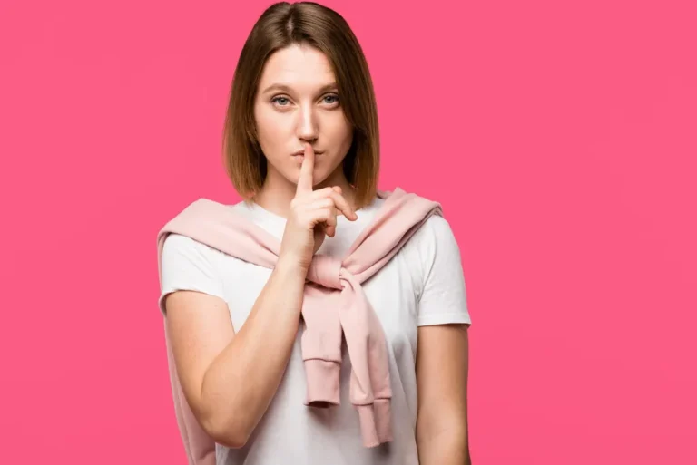 Woman looking at camera and doing silence gesture